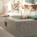Gray Manhattan Ethanol Fire Table with flame and windscreen outdoor