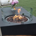 Metropolis Fire Table Dark Gray Sofas Flowers with Windguard and Flame Closeup